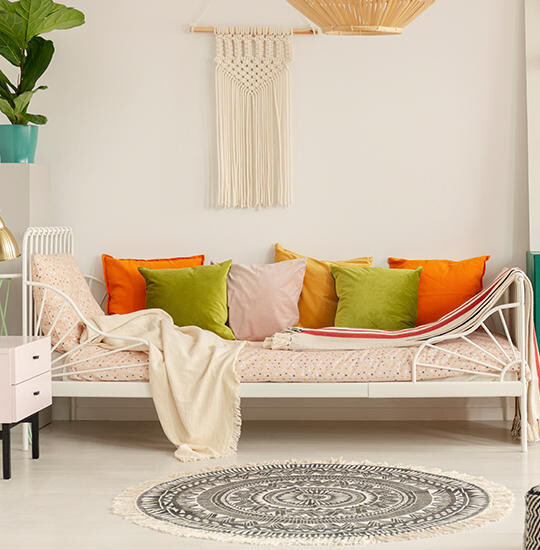 Metallbett mit bunten Kissen